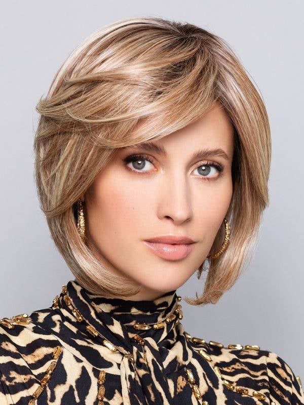 Perruque Nature Kiss Mono Gisela Mayer : mi-longue dégradée, frange côté, fibre résistante à 150°C pour un look naturel.