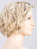 Perruque Turn Mono Part : coupe courte bouclée, volume naturel, effet rooted (racines foncées) ou mix (balayage).
