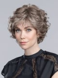 Perruque Aurora Comfort : coupe dégradée ondulée, effet rooted/mix, 100% fait main pour un confort léger et un rendu élégant.