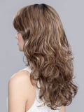 Perruque Pretty Hair Power : boucles Hollywood et frange épaisse, volume chic avec effet racines foncées ou balayage mix.
