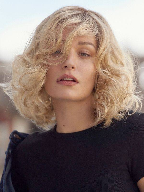 Perruque Chloé NJ Création mi-longue ondulée, frange sur le côté, tulle frontal discret et maintien Antiglisse