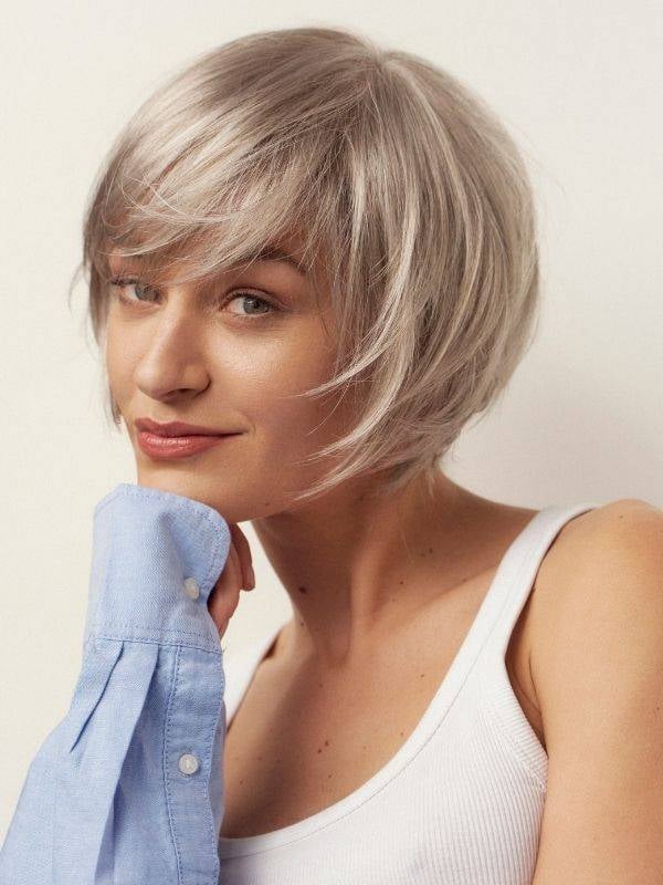 Perruque Frimousse NJ Création : coupe courte plongeante effilée, bordure tulle discrète, fibre synthétique NJ et maintien Antig