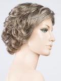 Perruque Aurora Comfort : coupe dégradée ondulée, effet rooted/mix, 100% fait main pour un confort léger et un rendu élégant.