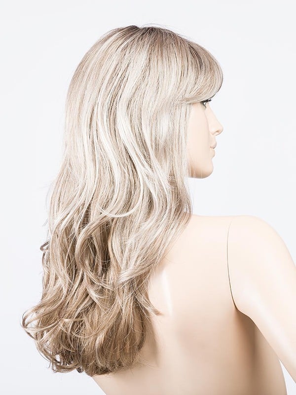 Perruque Pretty Hair Power : boucles Hollywood et frange épaisse, volume chic avec effet racines foncées ou balayage mix.