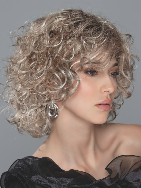 Perruque Loop Ellen Wille mi-longue bouclée en fibre synthétique avec lace front, volume naturel et bonnet standard. Comparez le